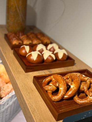 Dos platos de pretzels y otros pasteles sobre una mesa. en Hotel Herrnbrod & Ständecke, en Dreieich