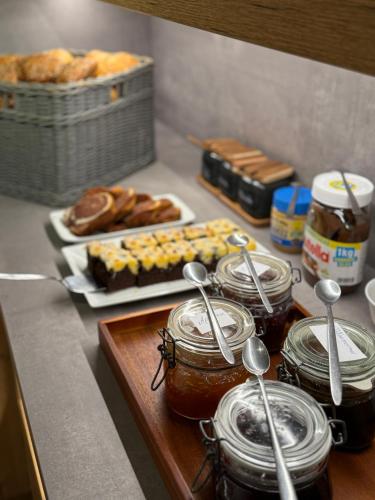 Un mostrador con tarros de miel, pasteles y pan. en Hotel Herrnbrod & Ständecke, en Dreieich