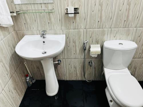 a bathroom with a white toilet and a sink at Pagoda Guest Nugegoda in Sri Jayewardenepura Kotte