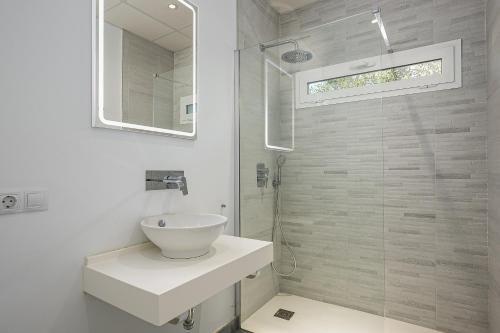 une salle de bain blanche avec lavabo et douche dans l'établissement Chill out of City 2, à Chiclana de la Frontera