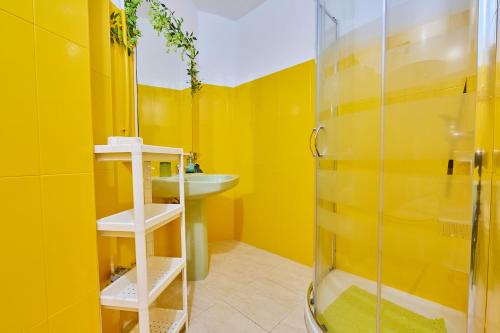 a yellow bathroom with a sink and a shower at El Caminito, CasaRural en Torredelcampo in Torre del Campo