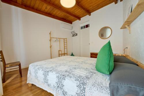 a bedroom with a bed with a green pillow on it at El Caminito, CasaRural en Torredelcampo in Torre del Campo