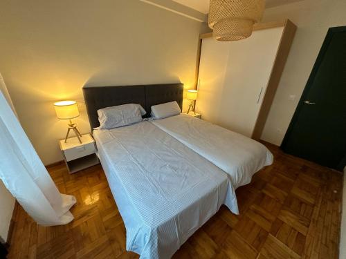 Un dormitorio con una gran cama blanca con dos lámparas. en Piso reformado centro de Oviedo, en Oviedo