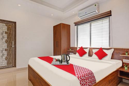 a bedroom with a large bed with red pillows at Hotel O Aura Hotel Rajdhani Residency in Rānchī