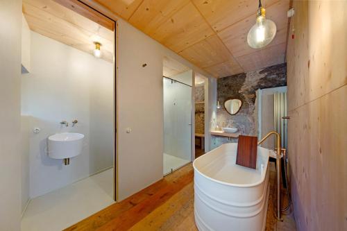 Un baño con bañera blanca y lavabo. en Cedä-M, en Dosoledo