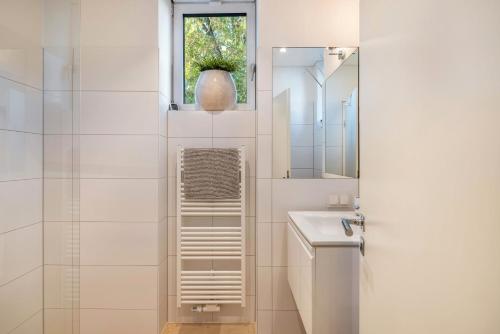 a white bathroom with a sink and a mirror at Ferienwohnung Ederweg in Wahlershausen