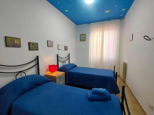 a bedroom with two beds and a blue ceiling at Casa A Matrice in Barrafranca