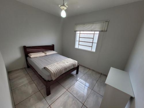een kleine slaapkamer met een bed en een raam bij Casa com 2 quartos no Aero Rancho in Campo Grande