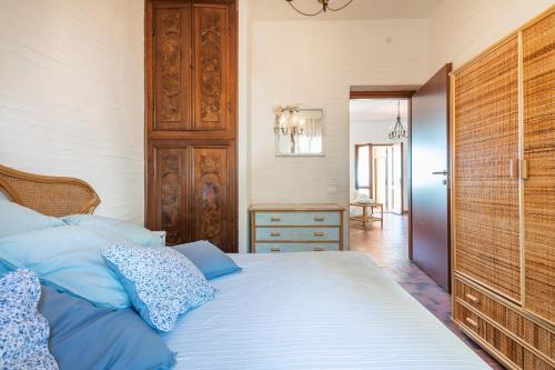 a bedroom with a bed with blue pillows on it at Casa Nicole in Sarroch