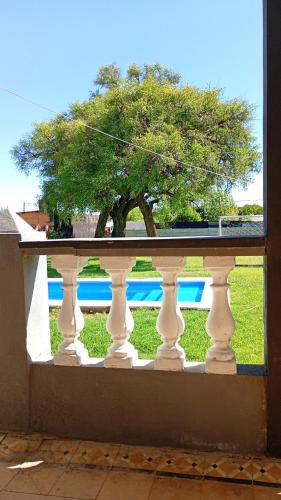 een uitzicht vanuit een raam op een wit hek met een boom bij La Rosadita in Paraná