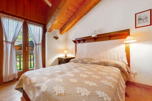 a bedroom with a bed and a large window at The Waterfall Chalet in Villaret