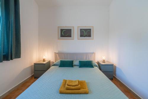 a bedroom with a bed with a blue bedspread at Villa Nonna Anna a Plemmirio in Siracusa