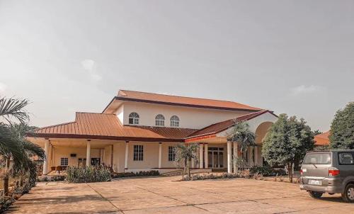 a house with a car parked in front of it at Hampton Resorts in Hohoe
