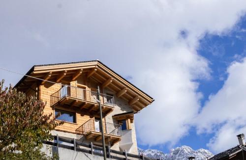 a building with a balcony and mountains in the background at Gran Zebrú B&B - high mountain in Valfurva