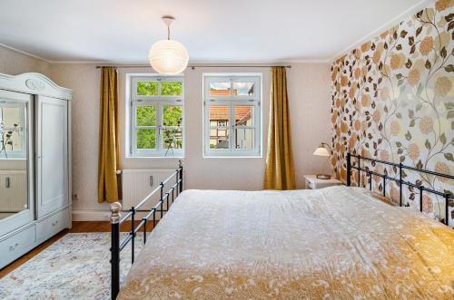 a bedroom with a bed and two windows at Villa Gottstreu in Gottstreu