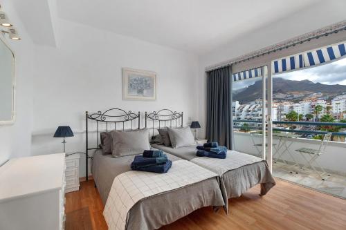 een slaapkamer met een bed en een groot raam bij Club Atlantis with views in Adeje