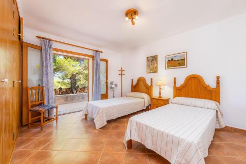a bedroom with two beds and a window at Villa Es Puig in S'Horta