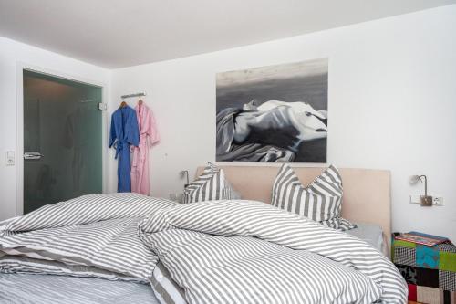 バート・ヴァルトゼーにあるFewo am Stadtsee - Bad Waldseeのベッドと壁に絵が飾られた寝室