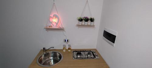 a kitchen with a sink and a stove and a tv at L'aurora in San Vito dei Normanni