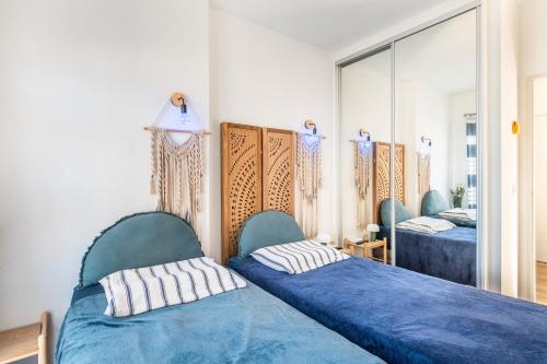a bedroom with two beds and a mirror at T3 Cros De Cagnes Bord De plage in Cagnes-sur-Mer