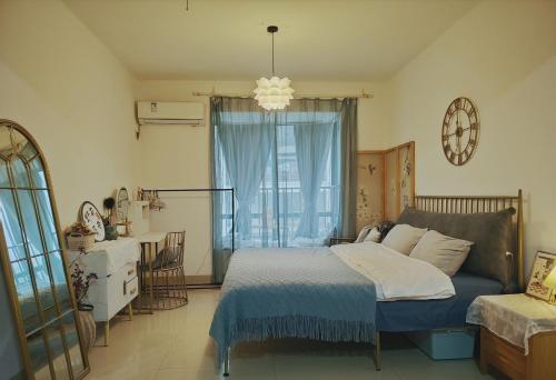 a bedroom with a bed and a large window at The Green Room in Nanning