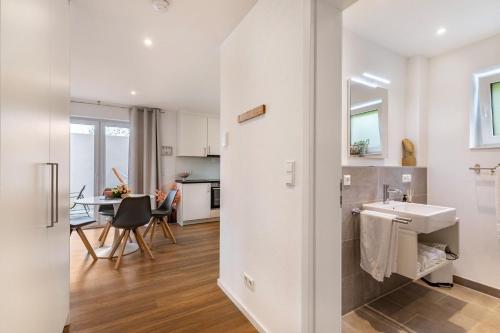 a kitchen and living room with a sink and a table at Fewo Parkside S1 - 8Min Legoland in Günzburg