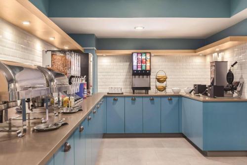 a kitchen with blue cabinets and a counter at Country Inn & Suites by Radisson, Erie, PA in Erie