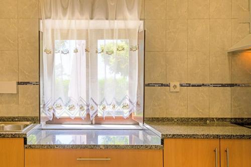 サン・テオトーニオにあるCasa Dos Líriosの窓とシンク付きのキッチンが備わります。