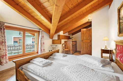 ein Schlafzimmer mit einem Bett und einem Fenster in der Unterkunft Au Petit Chevrot - Garden in Aosta