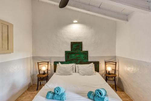 a bedroom with a bed with blue towels on it at Mas Tarres L'acacia Only Adults in Madremanya
