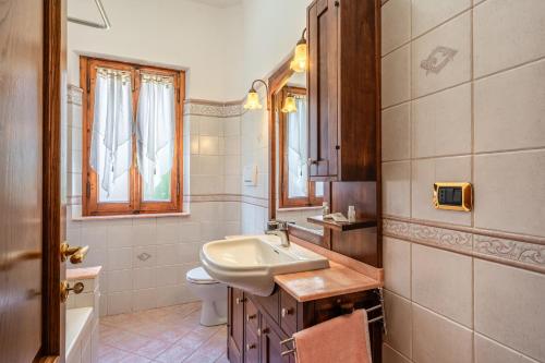 a bathroom with a sink and a toilet and a mirror at Tuscany Relax con giardino in Pieve a Nievole