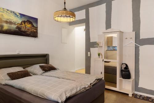 a bedroom with a large bed and a chandelier at Unterkunft Alte Schlosserei in Mühlhausen