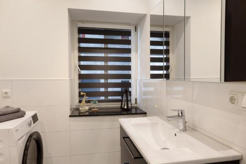 a white bathroom with a sink and a mirror at Unterkunft Alte Schlosserei in Mühlhausen