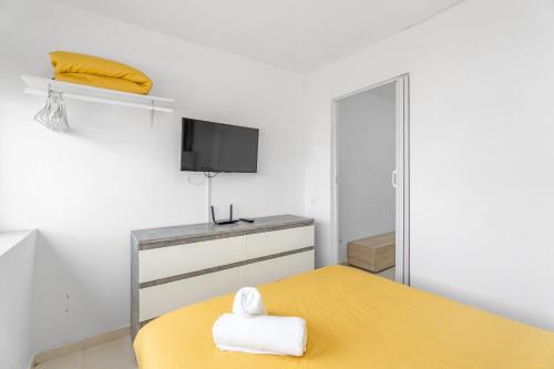 a bedroom with a yellow bed and a tv at Costa del Silencio Tenerife Sur in Arona