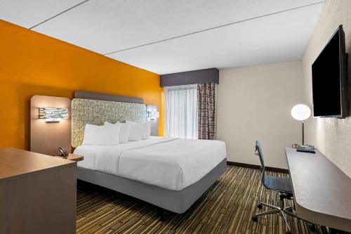 um quarto de hotel com uma cama grande e uma escrivaninha em Hotel Concord Syracuse, an Ascend Collection Hotel em East Syracuse