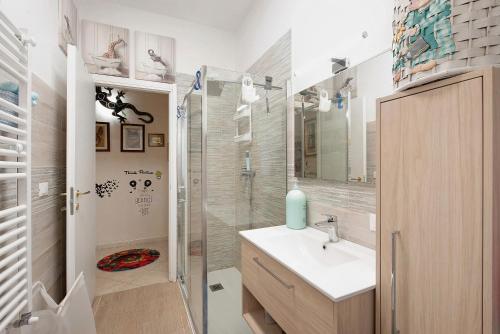 a bathroom with a sink and a glass shower at Zena in Genova