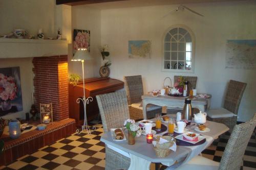 uma sala de estar com uma mesa e uma lareira em Le Clos Saint Jean em Sainte-Honorine-des-Pertes
