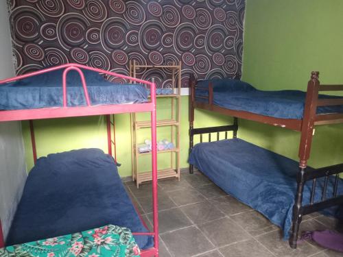 two bunk beds in a room with blue sheets at Macondo Hostel Itamambuca in Praia de Itamambuca
