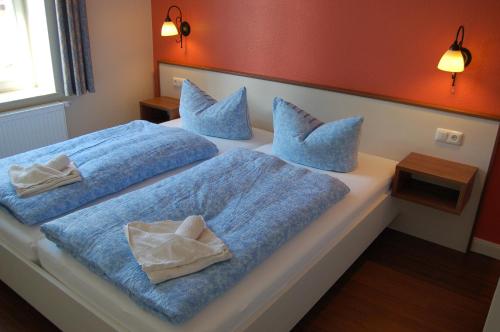 1 Schlafzimmer mit 2 Betten mit blauer Bettwäsche und Kissen in der Unterkunft Villa Paula in Bansin