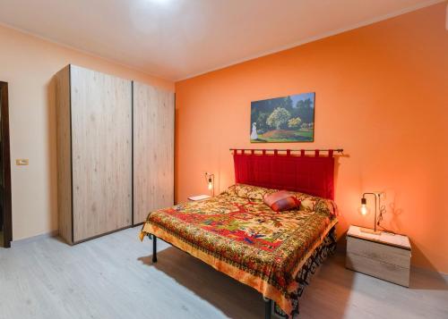 a bedroom with a bed and an orange wall at Casa Monet 90 wifi-parking in Capodimonte