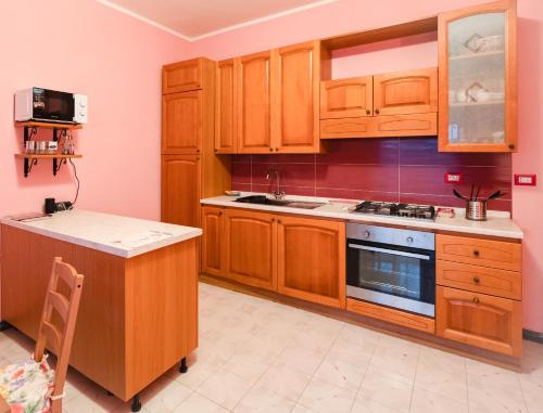 a kitchen with wooden cabinets and a stove at Casa Monet 90 wifi-parking in Capodimonte