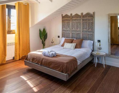 a bedroom with a large bed with a wooden floor at Camino Blanco in Ibeas de Juarros