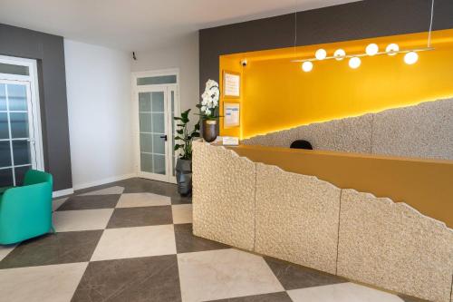 a lobby with a yellow counter and a checkered floor at Hotel Faranda Rias Altas, Ascend Hotel Collection in Oleiros