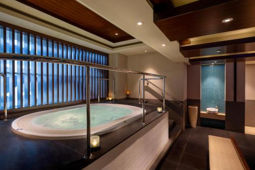 a large bathroom with a tub in a room at Grand Millennium Al Wahda Hotel and Executive Apartments Abu Dhabi in Abu Dhabi