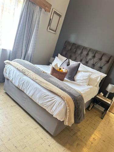 a bedroom with a large bed with white sheets and pillows at Ravens Nest in Bloemfontein