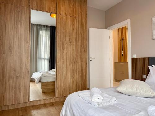 a bedroom with a large mirror and a bed at Urban Glow Next to Hospital by Cosher in Bŭnzareto