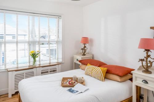 een slaapkamer met een wit bed en een raam bij The Bunker House in Newquay