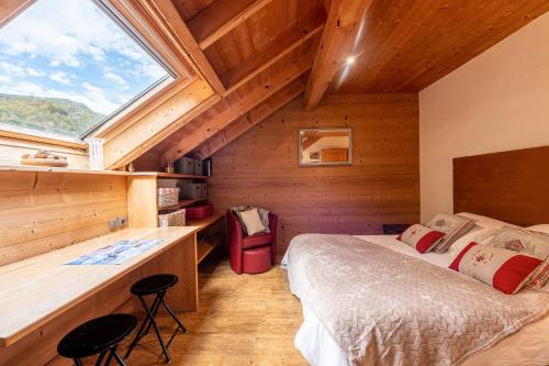 a bedroom with a bed and a desk and a window at Locdecharme in Les Clefs