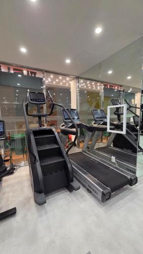 une salle de sport avec plusieurs tapis de course et un tapis roulant dans l'établissement JB Plus Hotel, à Busan