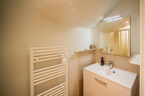 a bathroom with a sink and a mirror at Le Céleste - Parking Privatif - Terrasse - Netflix in Ballan-Miré